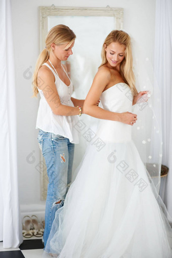 开始兴奋大一天年轻的新娘帮助婚礼衣服