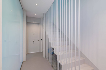 白色楼梯地板上软蓝色的照明现代建筑原始设计解决方案落地栅栏使金属白色棒效果失重