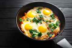 锅炸鸡蛋西红柿黑暗表格表面前视图蛋早餐鸡蛋早餐