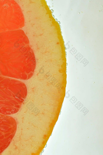 特写镜头多汁的葡萄柚片白色背景片红色的葡萄柚闪闪发光的水白色背景特写镜头垂直宏图像