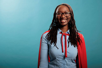 肖像非洲美国年轻的成人超级英雄女人穿红色的角蓝色的背景微笑相机