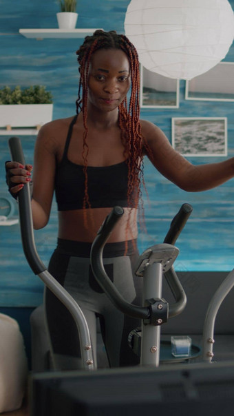 黑色的女人运动培训椭圆自行车练习有氧运动体育运动