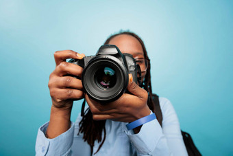 业余摄影师采取照片现代数码单反相机设备站蓝色的背景