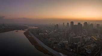 朦胧的日出高上升建筑庞大的城市河