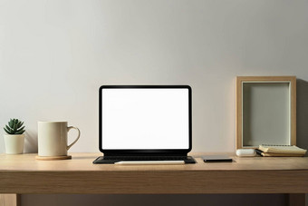 舒适的工作场所平板<strong>电脑图片</strong>框架咖啡杯室内植物木表格空白屏幕做广告