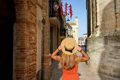有吸引力的旅行者女人辣椒辣椒挂阳台参观历史小镇南部意大利