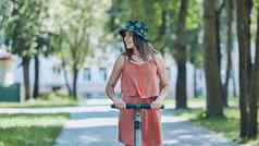 肖像女孩电踏板车骑公园夏天