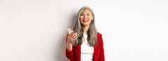 亚洲女企业家红色的夹克智能手机微笑快乐相机站白色背景