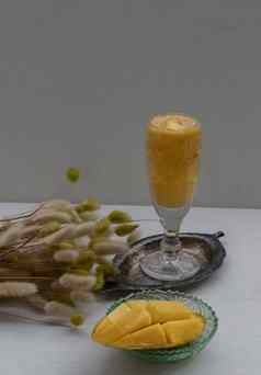 玻璃芒果摇新鲜的成熟的黄色的芒果水果新鲜的热带水果冰沙白色背景