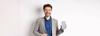 英俊的微笑推销员西装显示空智能手机屏幕演示应用程序站白色背景