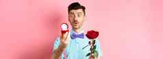 情人节一天浪漫的有趣的的家伙使婚礼建议结婚持有红色的玫瑰订婚环兴奋粉红色的背景