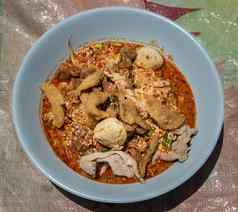 蛋面条泰国辣的汤炖猪肉猪肉球高脂肪的猪肉皮蓝色的碗