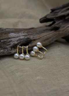金珠宝设置金珠宝时尚摄影金耳环白色珍珠时尚摄影耳环提出了木材