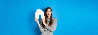 真正的房地产房地产经纪人保险概念兴奋女人喘气持有纸房子断路好交易站蓝色的背景