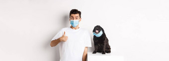 科维德动物检疫概念图像有趣的年轻的男人。小狗医疗面具老板显示拇指批准赞<strong>美白</strong>色背景