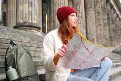 美丽的年轻的女人旅行者背包持有纸地图探讨了城市观光计划路线旅游受欢迎的景点