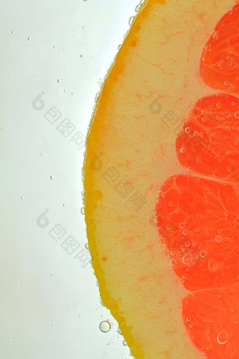 特写镜头多汁的葡萄柚片白色背景片红色的葡萄柚闪闪发光的水白色背景特写镜头垂直宏图像