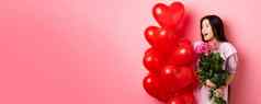 肖像亚洲十几岁的女孩爱持有花情人节一天心气球浪漫的日期粉红色的背景