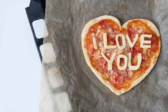 意大利心形状的披萨意大利蒜味腊肠番茄酱汁帕尔玛披萨酱汁马苏里拉奶酪橄榄石油羊皮纸纸奶酪爱爱概念情人节一天2月