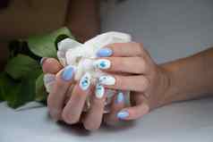 女孩美丽的白色蓝色的修指甲花束精致的牡丹