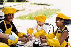 多民族厨师孩子们黄色的厨师他围裙烹饪面团面包店黑色的非洲高加索人孩子烹饪有趣的