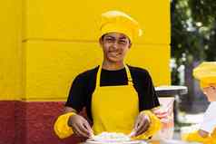 黑色的非洲少年烹饪厨师他黄色的围裙统一的烹饪面团面包店有创意的广告咖啡馆餐厅