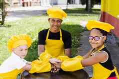 多民族的孩子们烹饪触碰手形成桩友谊跨国公司孩子们童年厨师厨师他黄色的围裙统一的把手