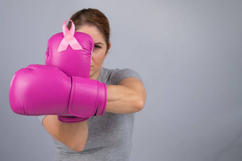 高加索人女人<strong>粉</strong>红色的拳击手套<strong>粉</strong>红色的丝带胸部灰色的背景战斗乳房癌症
