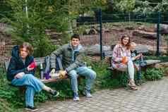 快乐家庭喝茶热水瓶森林照片可爱的迷人的妈妈。儿童穿着休闲装走坐着板凳上喝茶微笑城市公园