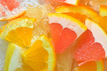 新鲜的片葡萄柚橙色水果蜂蜜葡萄柚白色背景块葡萄柚橙色水果蜂蜜葡萄柚闪闪发光的水白色背景特写镜头水平宏图像前视图平设计夏天水果背景