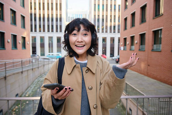 肖像年轻的朝鲜文女人耳机惊讶惊讶持有移动电话意识到神奇的发生了<strong>欢呼</strong>庆祝<strong>胜利</strong>