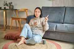 肖像女人坐着地板上智能手机深思熟虑的指出手指横幅促销广告前角落里
