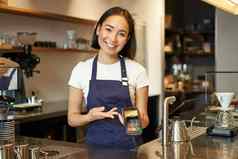 肖像亚洲咖啡师女孩计数器显示卡机客户端支付非接触式采取订单站咖啡馆