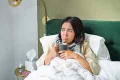 流感病人年轻的女人感觉生病的发热捕捉与说谎床上热茶采取药物流感