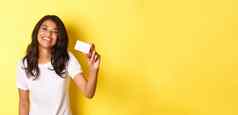 图像可爱的非裔美国人女人微笑快乐显示信贷卡站黄色的背景