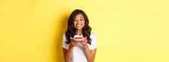 肖像美丽的非裔美国人女孩庆祝生日微笑快乐生日蛋糕蜡烛站黄色的背景