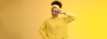 友好的自信的精力充沛的非裔美国人微笑健康的女孩眨眼积极的的态度咧着嘴笑快乐的显示和平胜利幸运的手势持有手腰自信黄色的背景