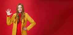 女孩给星星太棒了互联网商店买了装秋天天气显示提高了棕榈微笑广泛的站时尚的温暖的黄色的外套红色的背景