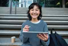 肖像亚洲女孩学生赶时髦的人坐着楼梯数字平板电脑杯咖啡吸引了数字艺术使设计项目
