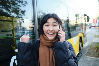快乐亚洲女孩会谈移动电话惊讶惊讶伟大的新闻实现目标听到令人兴奋的