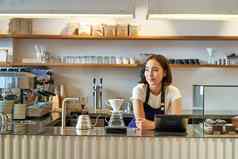 快乐微笑亚洲咖啡师女孩计数器工作回来终端酝酿过滤器工具包使咖啡咖啡馆