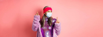 科维德社会距离时尚概念快乐的亚洲高级女人喜欢聚会，派对跳舞呼吸器闪亮的紫色的衣服站粉红色的背景