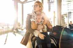 母亲旅行婴儿婴儿男孩孩子走推婴儿巡回演出的演员行李车前面机场终端站