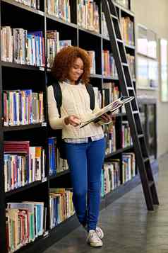 图书馆的地方研究年轻的女人研究书站图书馆书架上