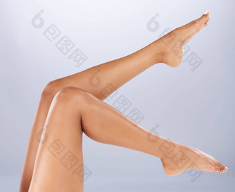 腿健康护肤品化妆品健康灰色工作室背景腿梳理光滑的皮肤软腿护理幸福剃须美拔毛水疗中心光着脚