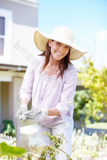 保持植物浇水夏天热肖像美丽的女人浇水植物花园