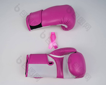 粉红色的拳击手套粉红色的丝绸丝带白色背景乳房癌症概念