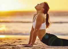 瑜伽Cobra伸展运动女人海滩健身健康健康日落Zen脉轮女瑜珈练习普拉提冥想培训拉伸锻炼在户外海滨