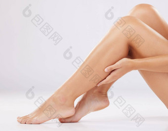 护肤品腿女人化妆品健康清晰的皮肤灰色工作室背景腿脚女光滑的治疗发光发光梳理自然美奢侈品护理