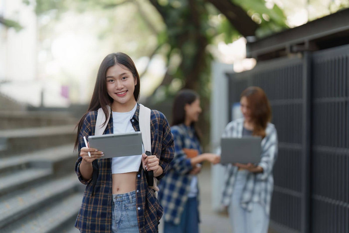 美丽的年轻的亚洲女人大学学生朋友在户外大